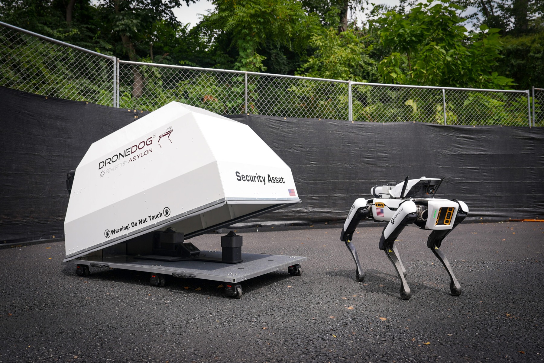 Asylon source photograph of a robotic dog and docking equipment. Context image; the pictured location is not identified as Bayer’s site.