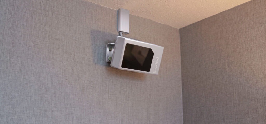 Blickfeld source wall-mounting illustration for QbProtect S. Product visualization; no customer location or measured detection outcome is depicted.